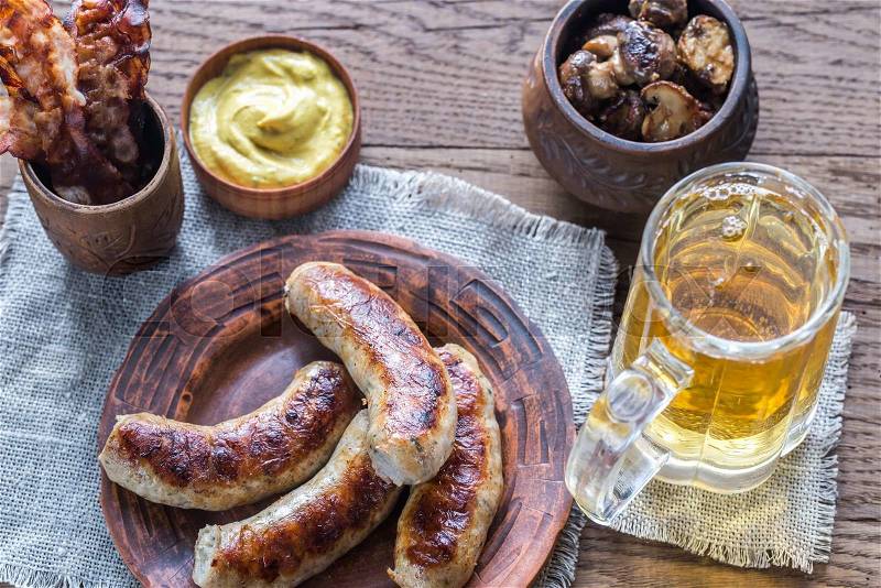 Grilled sausages with fried bacon rashers and mushrooms, stock photo