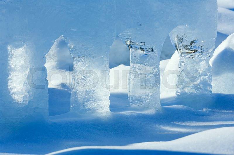 Transparent columns of ice on the snow illuminated by the spring sunshine, stock photo