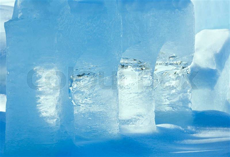Transparent columns of ice on the snow illuminated by the spring sunshine, stock photo