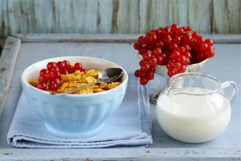 Healthy breakfast granola corn with red currant (in blue bowl), stock photo
