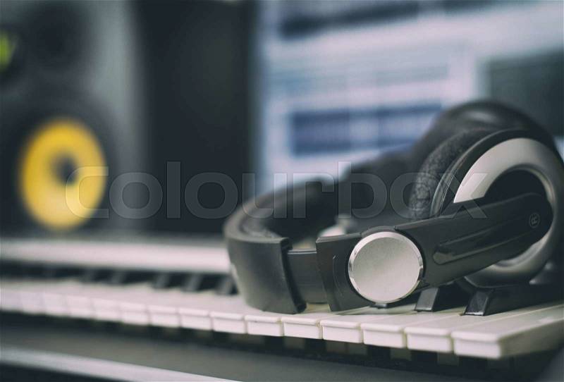 Audio earphones. Home recording studio with professional monitors and midi keyboard, stock photo