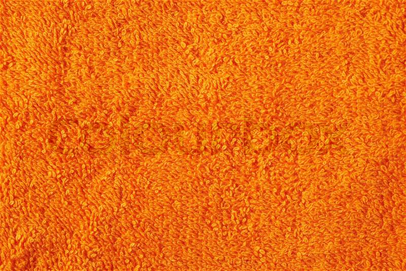 Terry cloth orange towel fragment as a background texture, stock photo