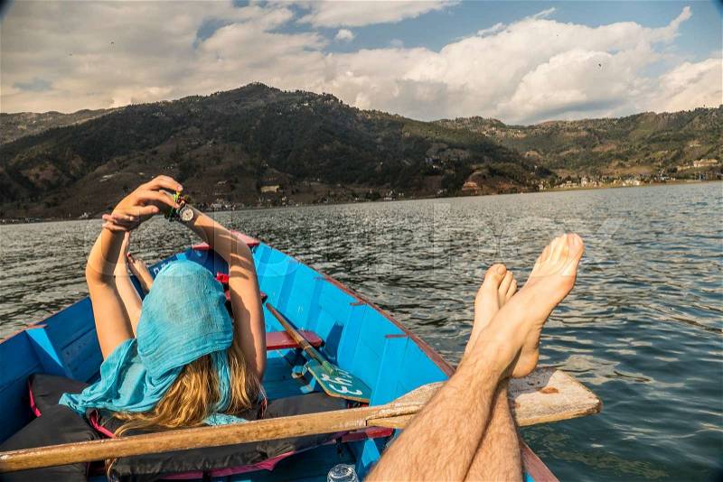 Point of view angle of man and woman relaxing together in row boat off the coast of quiet vacation spot, stock photo