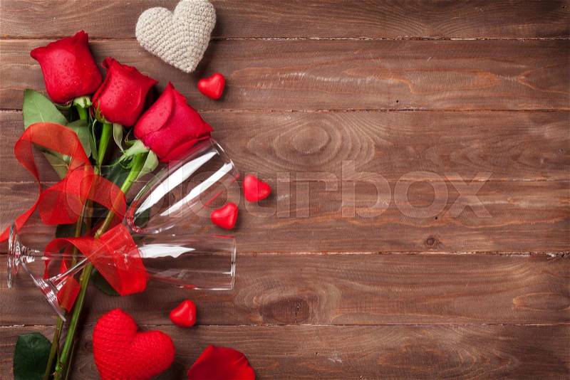 Red roses, hearts and champagne glasses over wood with copy space. Valentines day background, stock photo