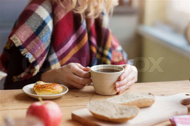 Beautiful woman relaxing at home with notebook and cup of coffee, stock photo