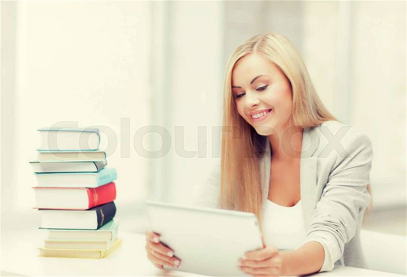 Student with tablet pc and stack of books, stock photo