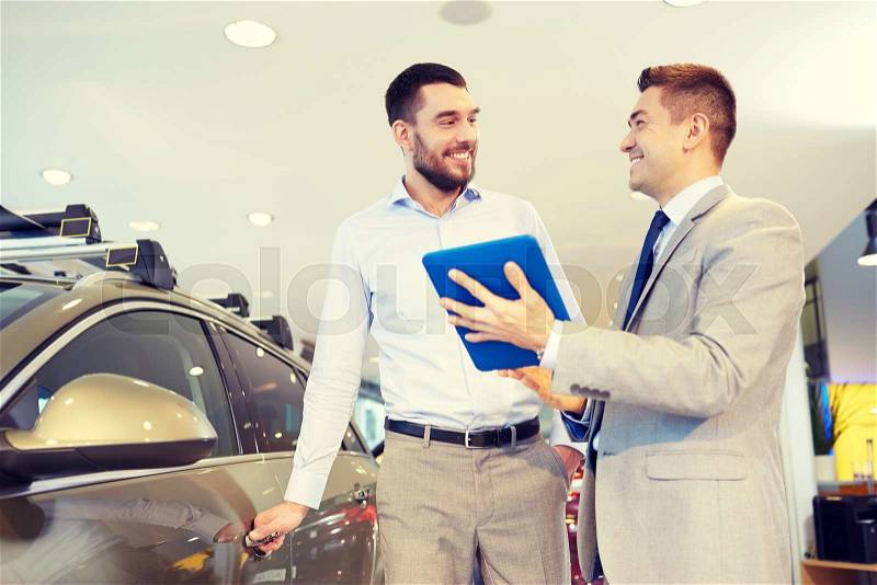 Auto business, car sale, technology and people concept - happy man and car dealer with tablet pc computer in auto show or salon, stock photo