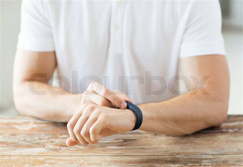 Business, technology and people concept - close up of male hands with heart-rate watch at home, stock photo