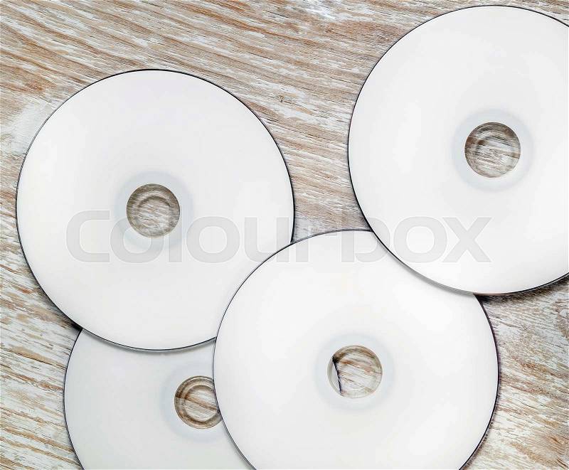 Blank CD and DVD on light wooden background. Mock-up for design presentations and portfolios. Top view, stock photo