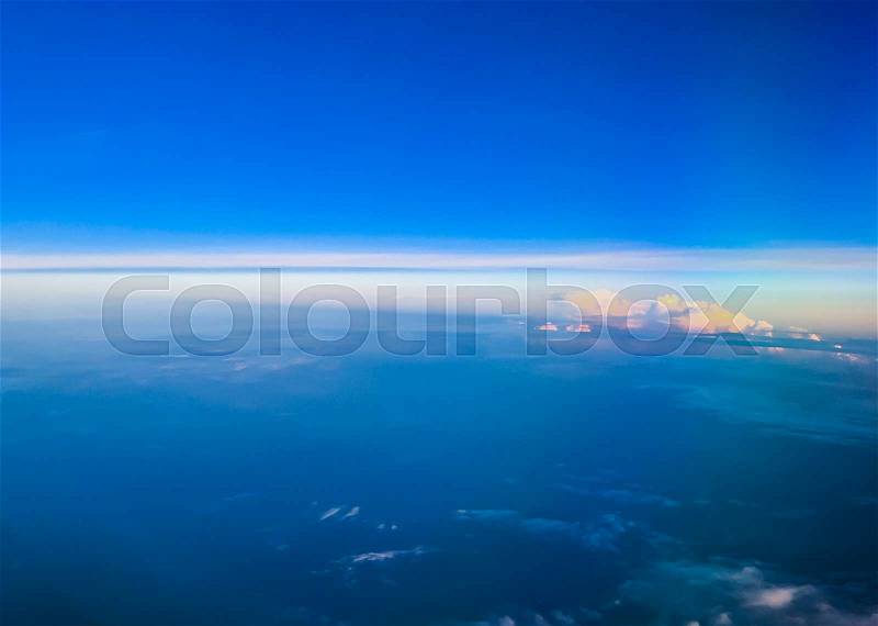 Window view in airplane above the blue sky with cloud, stock photo