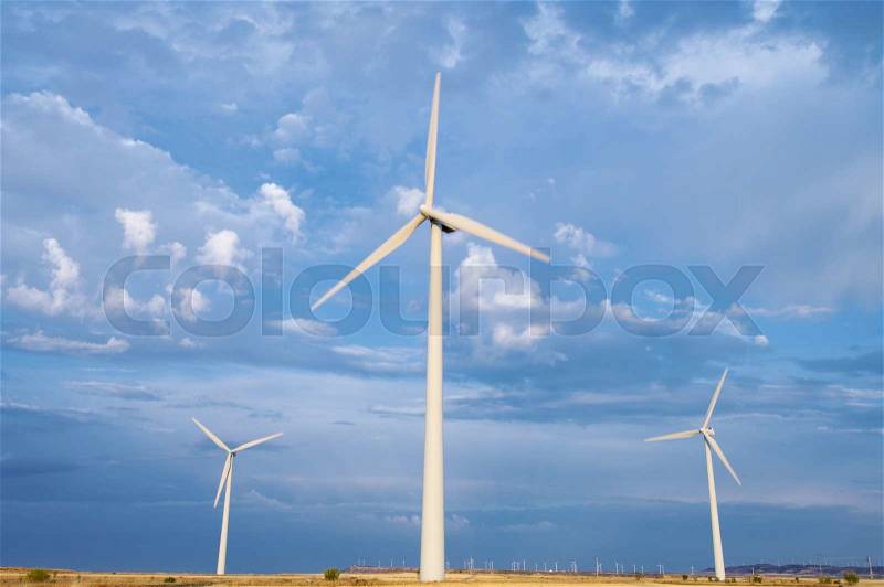 Windmills group with cloudy sky at sunset in Gurrea de Gallego, Huesca, Aragon, Spain, stock photo