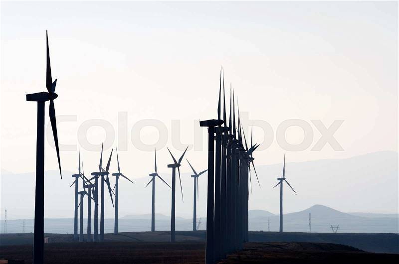 Aligned windmills for renowable electric production with white sky, Pozuelo de Aragon, Zaragoza, Aragon, Spain, stock photo