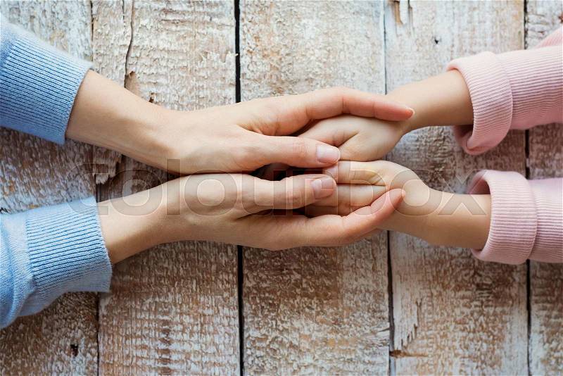 Unrecognizable mother and her daughter holding hands, stock photo