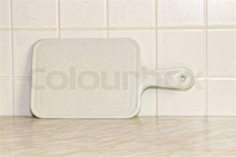 White plastic cutting board with empty space for your menu text on kitchen table, stock photo