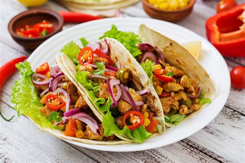 Mexican tacos with meat, corn and olives on wooden background, stock photo