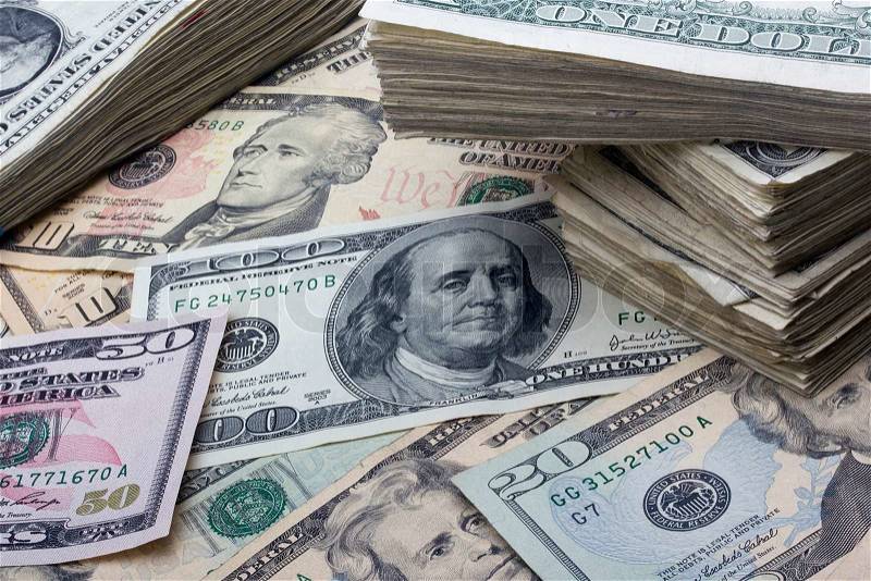 Variety of American money laid out under a stack of cash, stock photo