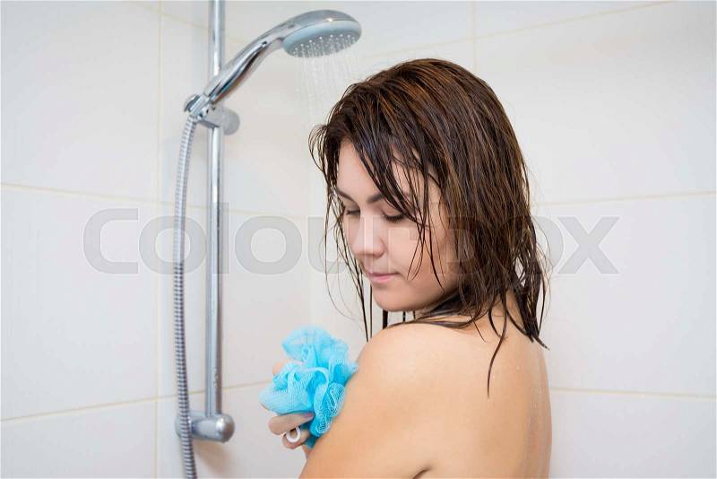 Body care concept - young beautiful woman washing her body with sponge in shower, stock photo