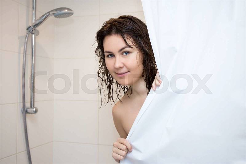 Body care concept - young woman standing in shower and covering her body with curtain, stock photo