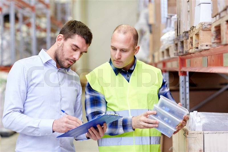 Wholesale, logistic, people and export concept - manual worker and businessmen with clipboard and boxes at warehouse, stock photo