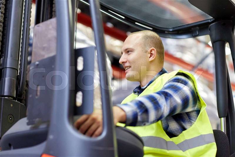Wholesale, logistic, loading, shipment and people concept - man or loader operating forklift loader at warehouse, stock photo