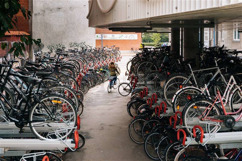 Cycle parking in Odense, Denmark. Girl is getting her bike, stock photo