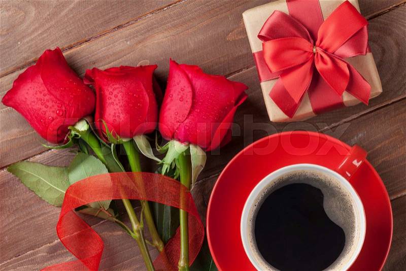 Red roses, Valentines day gift box and coffee cup on wooden background. Top view, stock photo