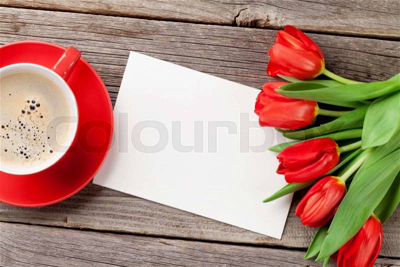 Red tulips, Valentines day greeting card and coffee cup over wooden table. Top view with copy space, stock photo