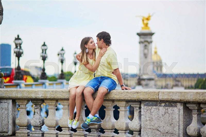 Romantic dating couple of tourist in Paris, on the famous Alexandre III bridge over the Seine, stock photo