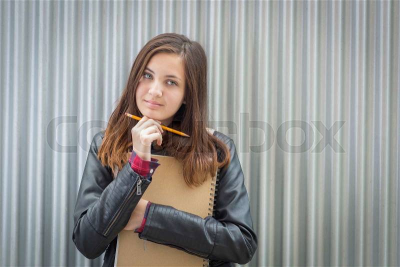 Pretty Young Melancholy Female Student With Books and Pencil Looking to the Side, stock photo