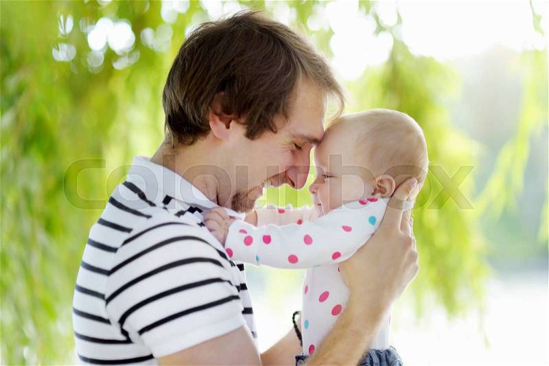 Happy young father and his daughter at summer park, stock photo