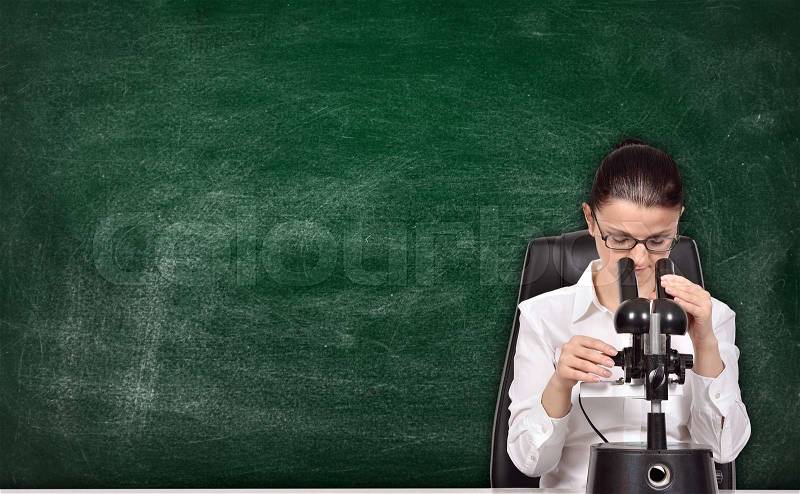 Scientific researcher woman sitting in laboratory and studying the chemical sample, stock photo