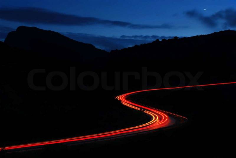Night roads in the mountains with a stream of cars, stock photo
