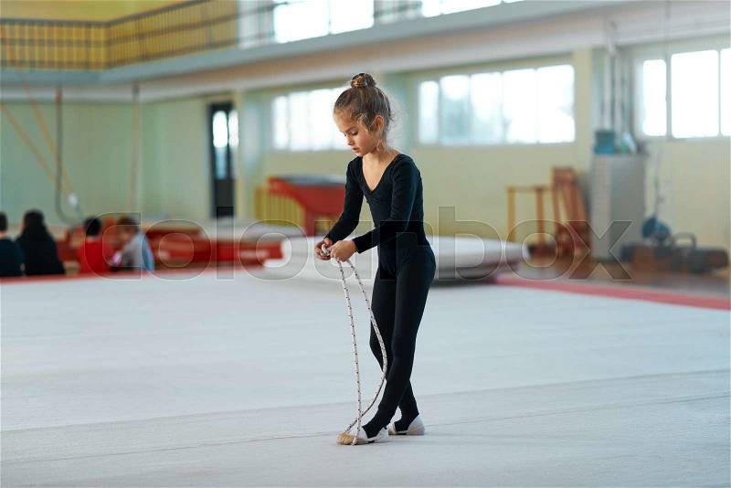 Girl trains with a rope in rhythmic gymnastics, stock photo
