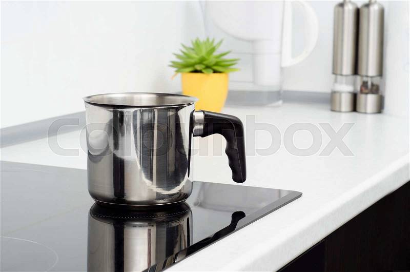 Mug in modern kitchen with induction stove, stock photo