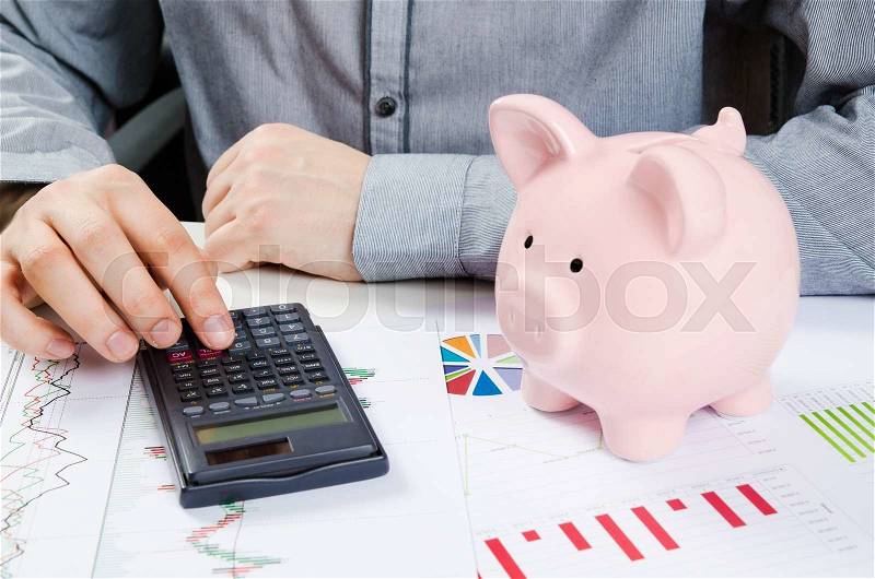 Man calculates money. Piggy bank and business documents on desk, stock photo