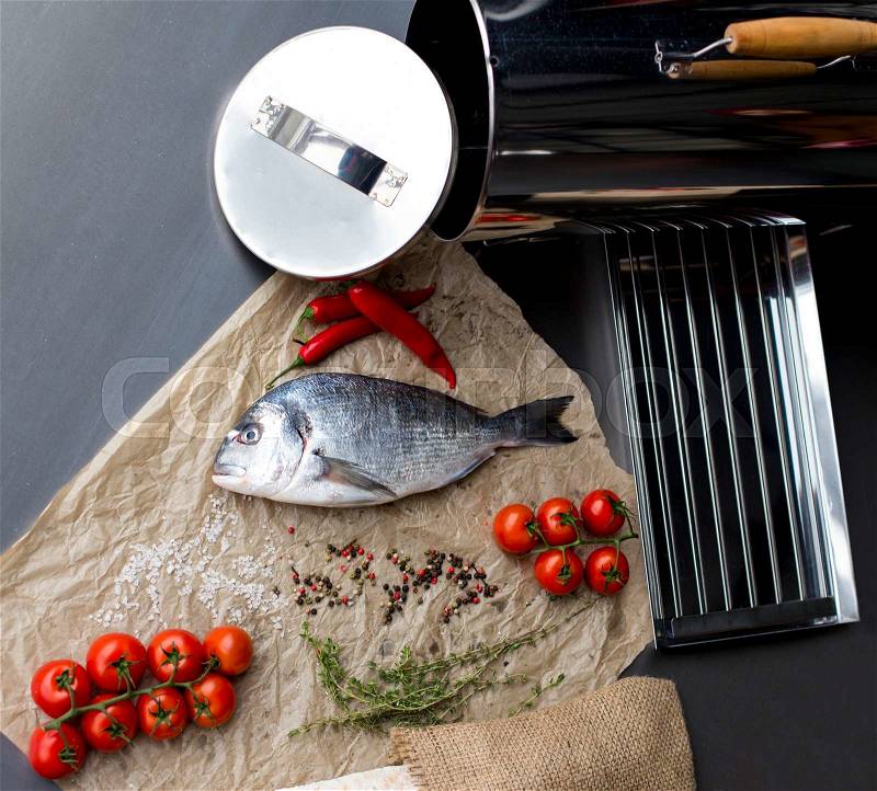 Food background with fresh fish on dark board. Fish with spices and vegetables. healthy food, diet or cooking concept, stock photo