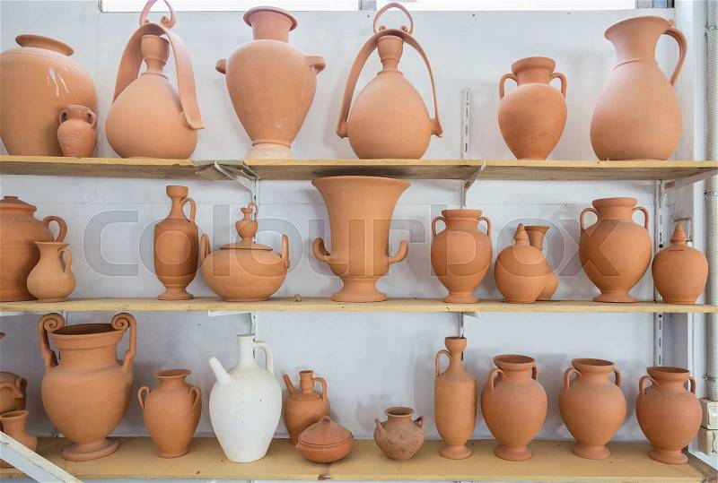 Shelves with different brown clay jars and pots made by greek artists, stock photo