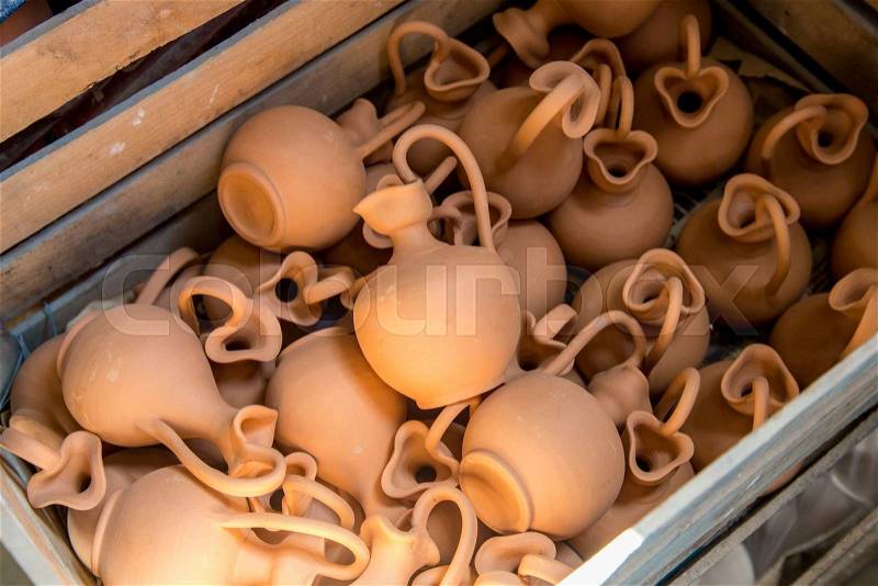 Box full of small brown clay jars made by greek artists, stock photo