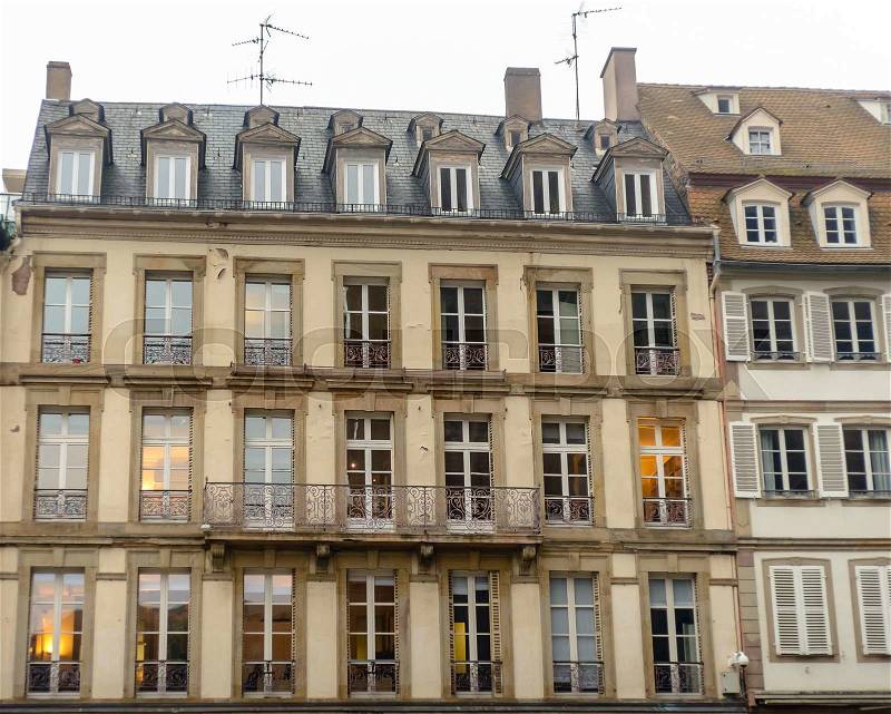 The facade of french building in modern style with windows and french balconies, stock photo