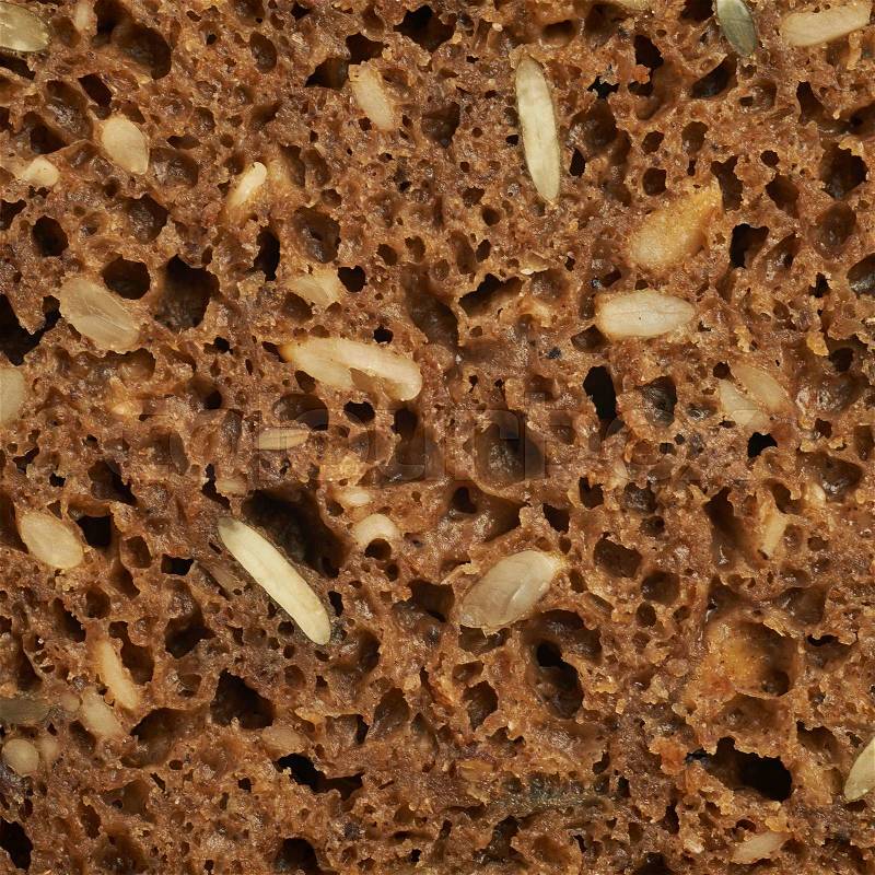 Black bread with seeds close-up fragment as a backdrop texture composition, stock photo