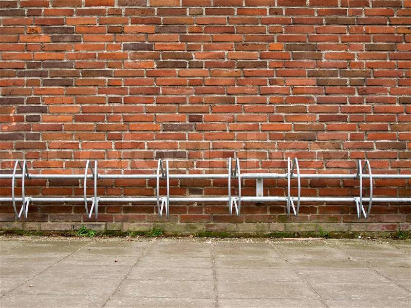 An empty bicycle rack on a brick wall simple structure, stock photo