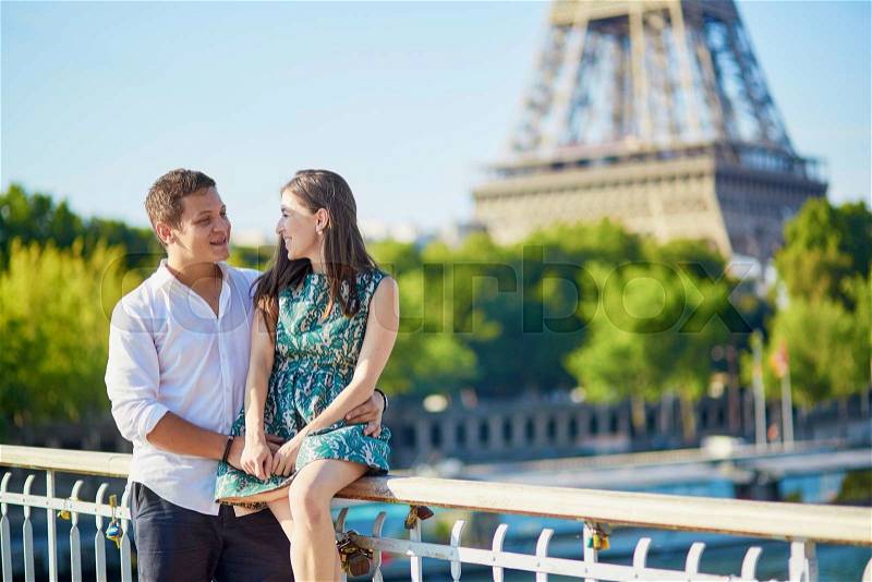 Young romantic couple spending their vacation in Paris, France. Dating couple posing near the Eiffel tower, stock photo