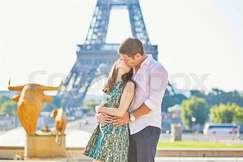 Young romantic couple in Paris near the Eiffel tower, enjoying their vacation to Paris, stock photo