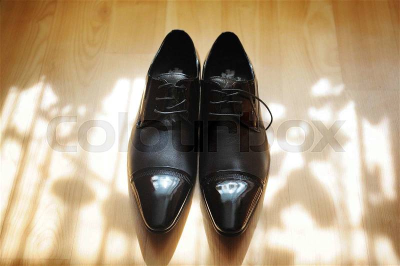 Pair of black men\'s shoes for groom standing on the floor, stock photo