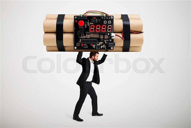 Small businessman carrying big bomb over light grey background, stock photo