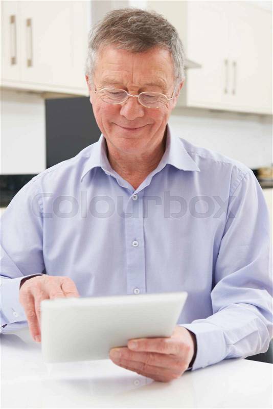 Senior Man Using Digital Tablet At Home, stock photo