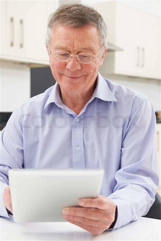 Senior Man Using Digital Tablet At Home, stock photo