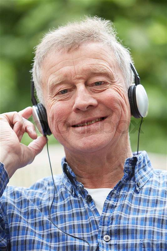 Senior Man Relaxing Listening To Music On Headphones, stock photo