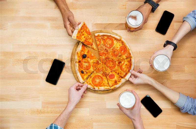Top view of group of students meeting and eating pizza together , stock photo