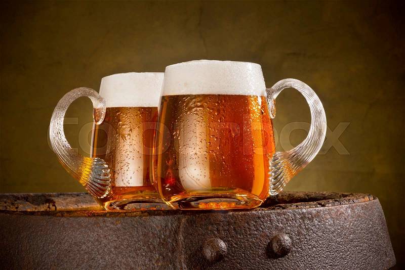 Two glasses of beer on the old barrel, stock photo